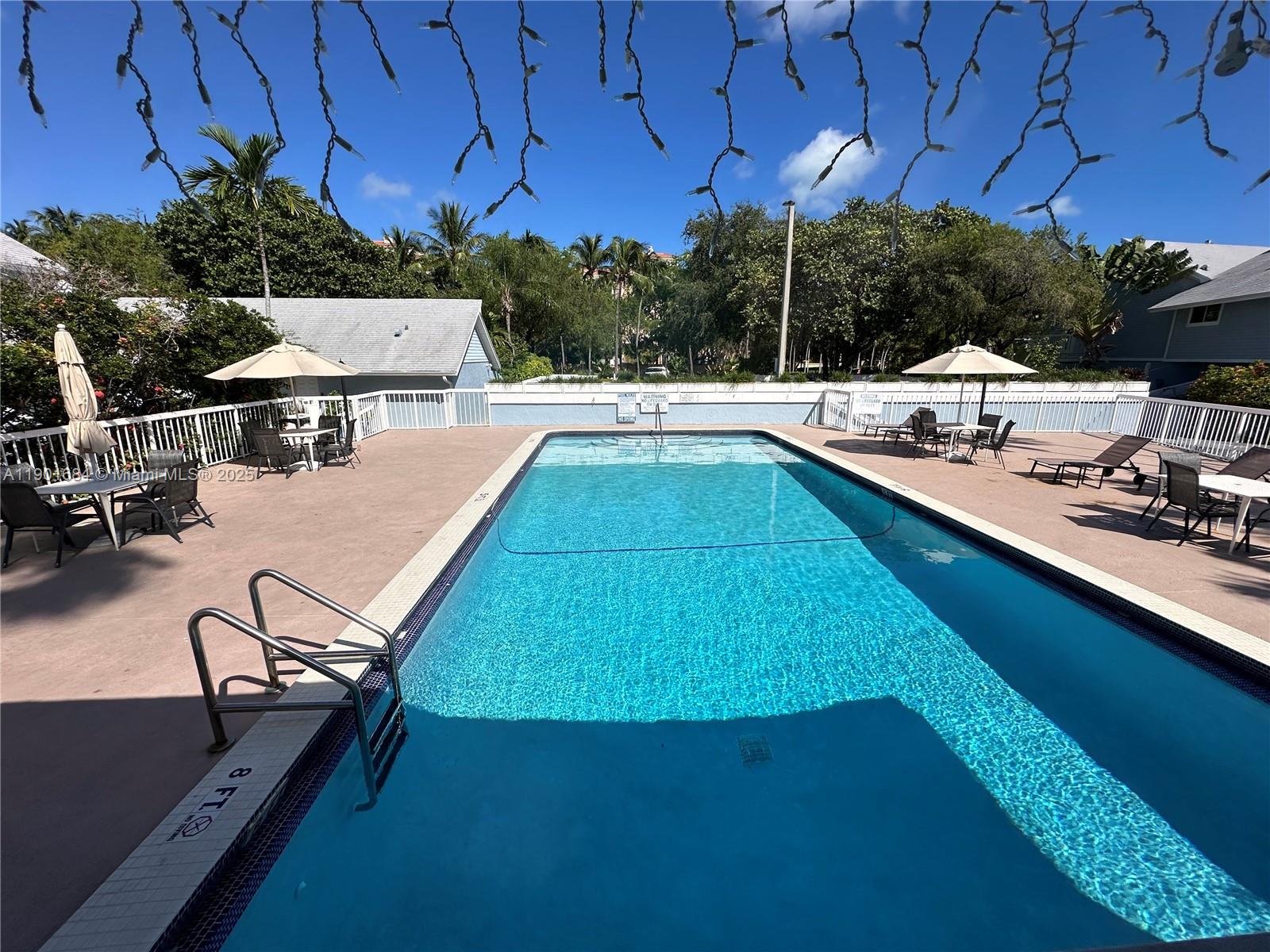 798 Crandon Boulevard, Unit 38C Key Biscayne, FL 33149 - Photo 30 of 33 a view of a swimming pool with lounge chair