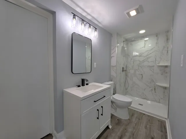 a bathroom with a sink a toilet and shower