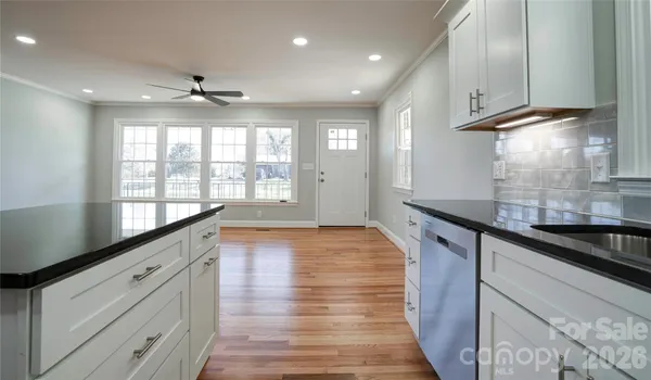 a large kitchen with stainless steel appliances granite countertop a sink and wooden floor