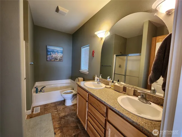 a bathroom with a granite countertop sink mirror vanity and toilet