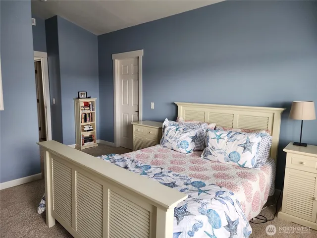 a bedroom with a large bed and a chandelier