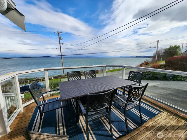 a view of a roof deck with table and chairs with wooden floor