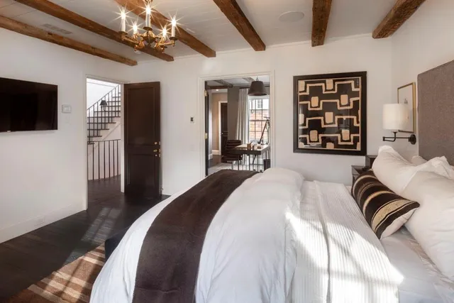 a spacious bedroom with a bed couch and a flat screen tv