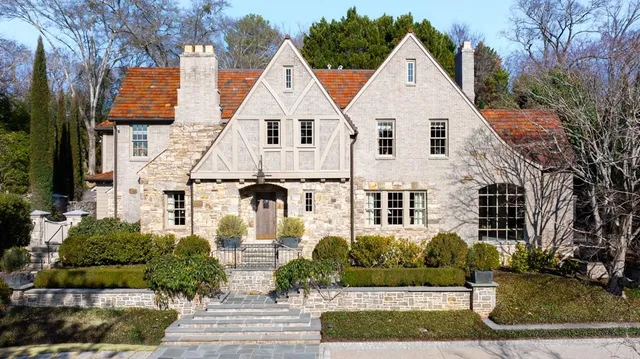 a view of a white house with large windows and a yard