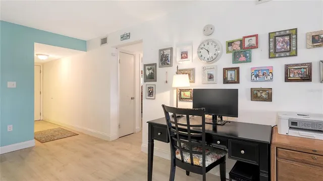 a view of a workspace with furniture and wooden floor