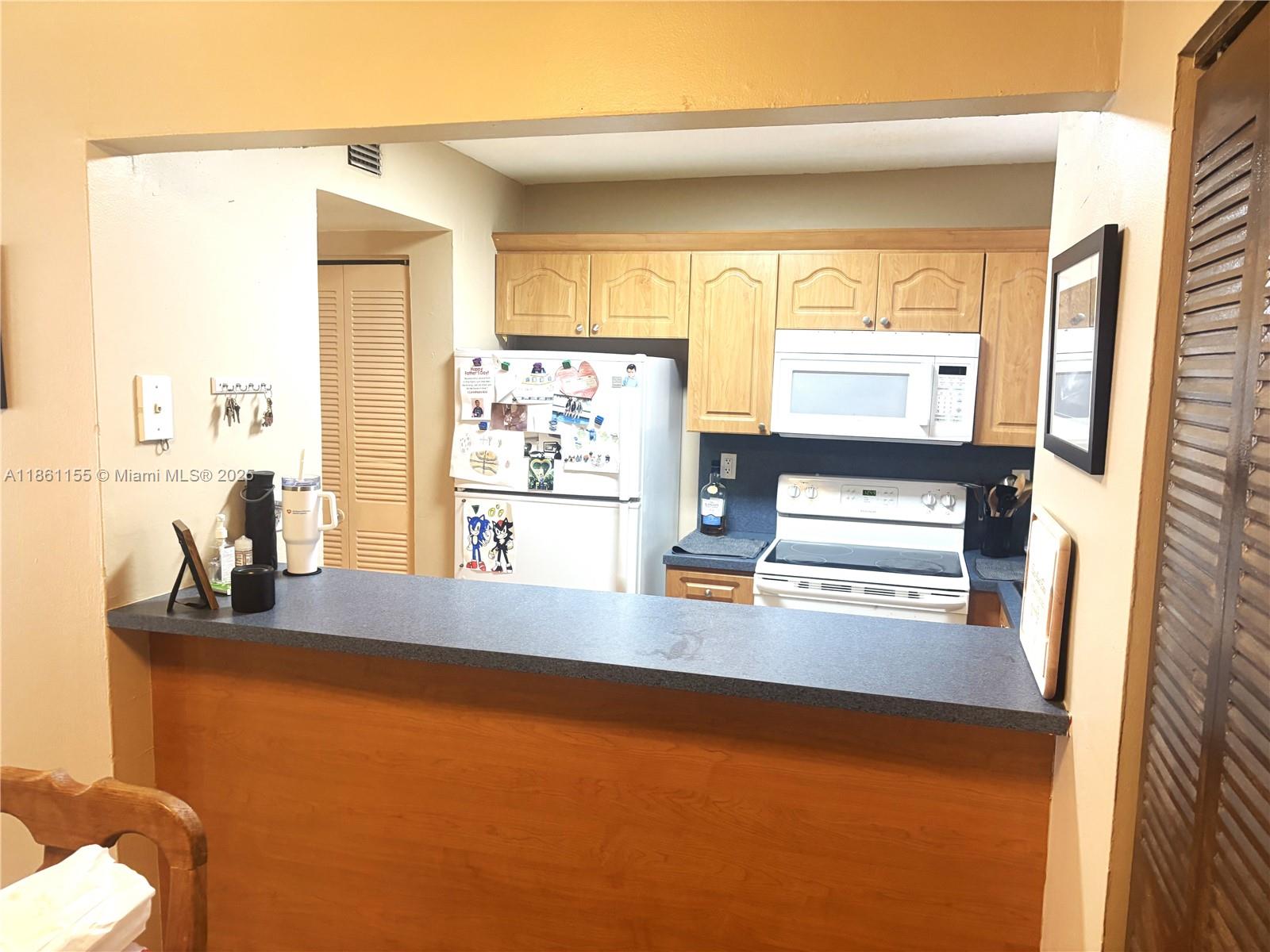 8889 Fontainebleau Boulevard, Unit 204 Miami, FL 33172 - Photo 7 of 28 a kitchen with stainless steel appliances a sink and a refrigerator
