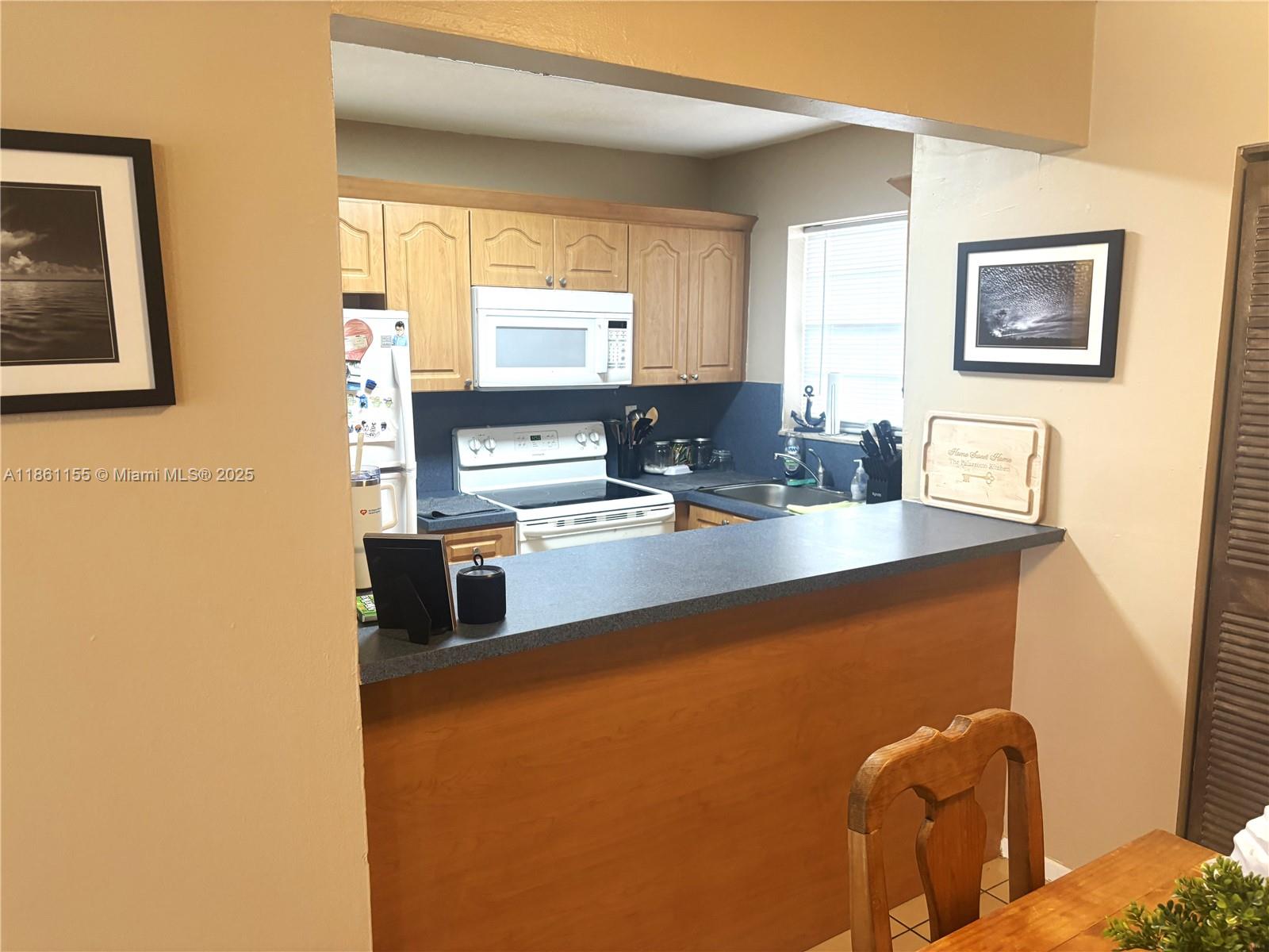 8889 Fontainebleau Boulevard, Unit 204 Miami, FL 33172 - Photo 8 of 28 a kitchen with stainless steel appliances granite countertop a refrigerator and a stove top oven
