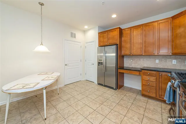 a kitchen with stainless steel appliances granite countertop a refrigerator and a sink