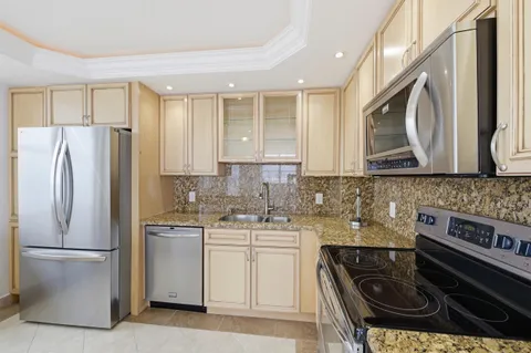a kitchen with stainless steel appliances granite countertop a stove and cabinets