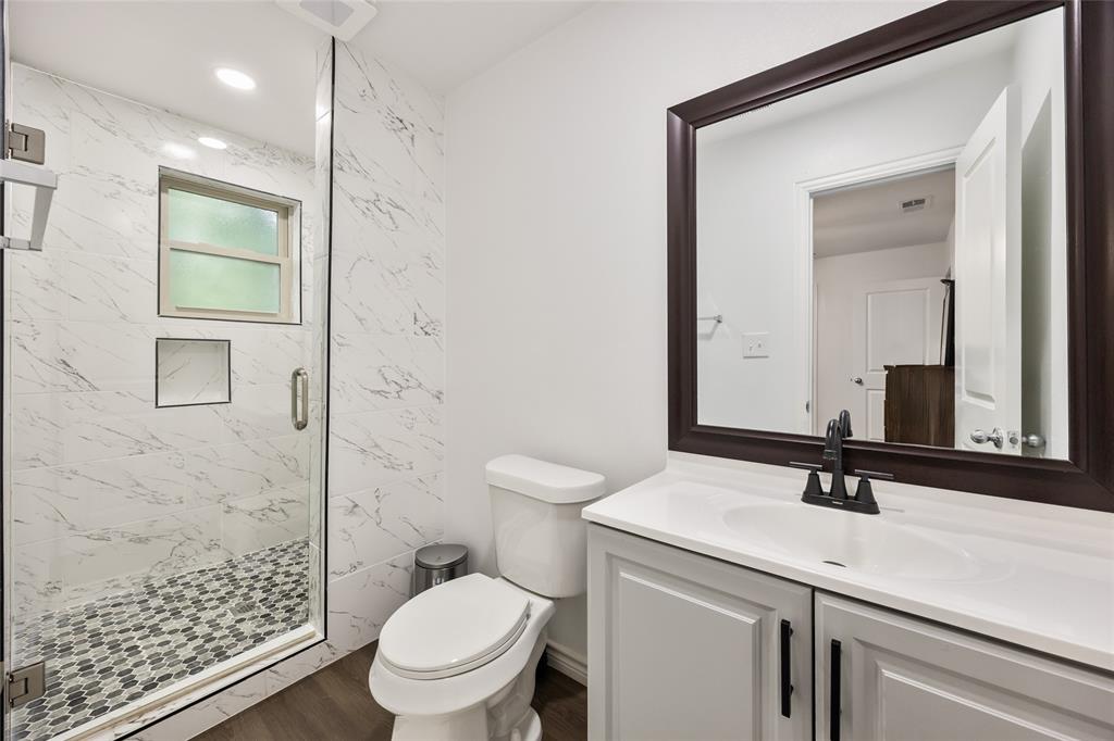 1005 Iowa Street Irving, TX 75060 - Photo 13 of 23 a bathroom with a sink a toilet and shower