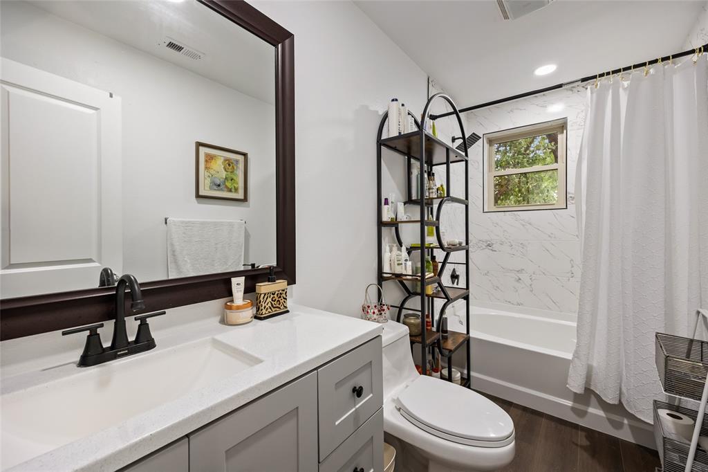 1005 Iowa Street Irving, TX 75060 - Photo 14 of 23 a bathroom with a sink a toilet and shower