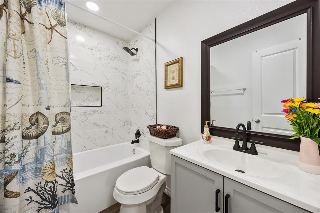 1005 Iowa Street Irving, TX 75060 - Photo 15 of 23 a bathroom with a sink a toilet and shower