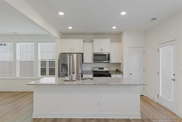 a kitchen with stainless steel appliances a refrigerator sink and microwave