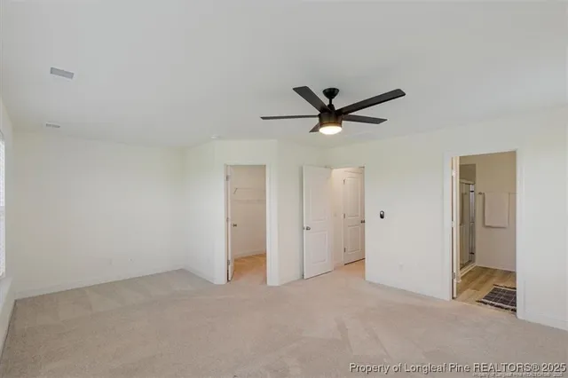 a view of a livingroom with a ceiling fan and wooden floor