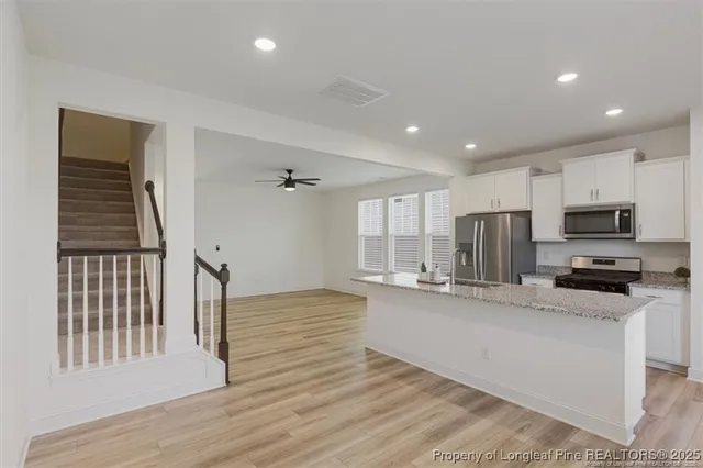 a large kitchen with stainless steel appliances granite countertop a stove a sink and a refrigerator