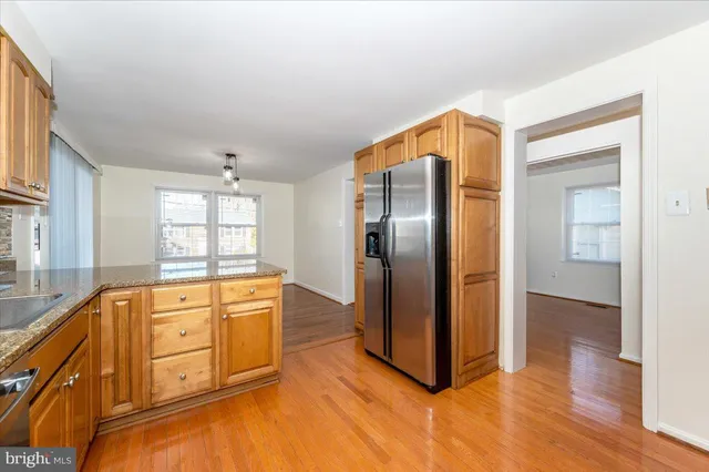 a kitchen with stainless steel appliances granite countertop a refrigerator and a stove