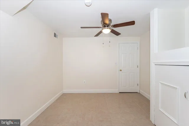a view of a room with a ceiling fan and a fan