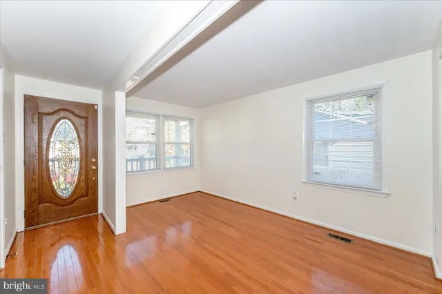 a view of empty room with window and wooden floor