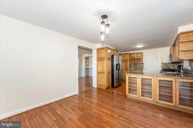 a view of a kitchen with wooden floor and stainless steel appliances