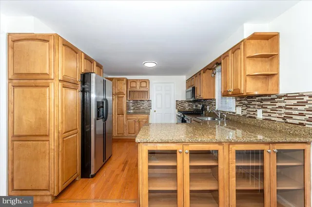 a kitchen with stainless steel appliances granite countertop a refrigerator and a sink