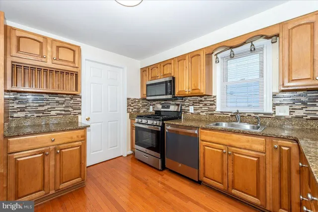 a kitchen with granite countertop cabinets stainless steel appliances a sink and a window