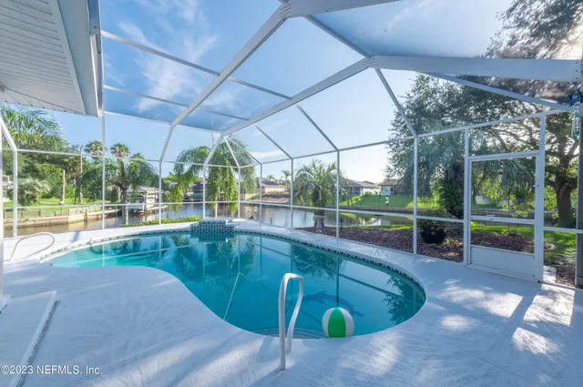 a view of a patio with a table chairs and a floor to ceiling window
