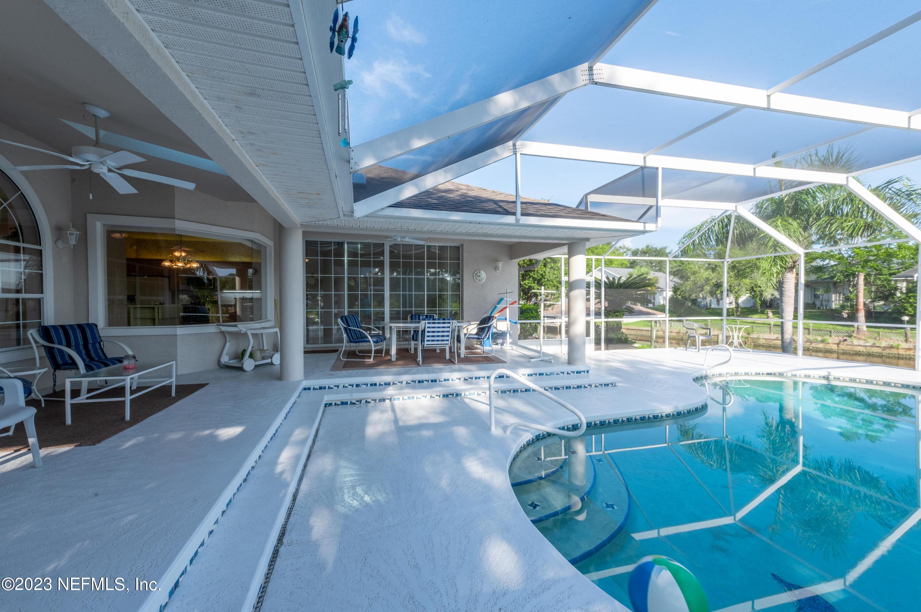 13 Clear Court Palm Coast, FL 32137 - Photo 16 of 60 a view of a patio with table and chairs under an umbrella