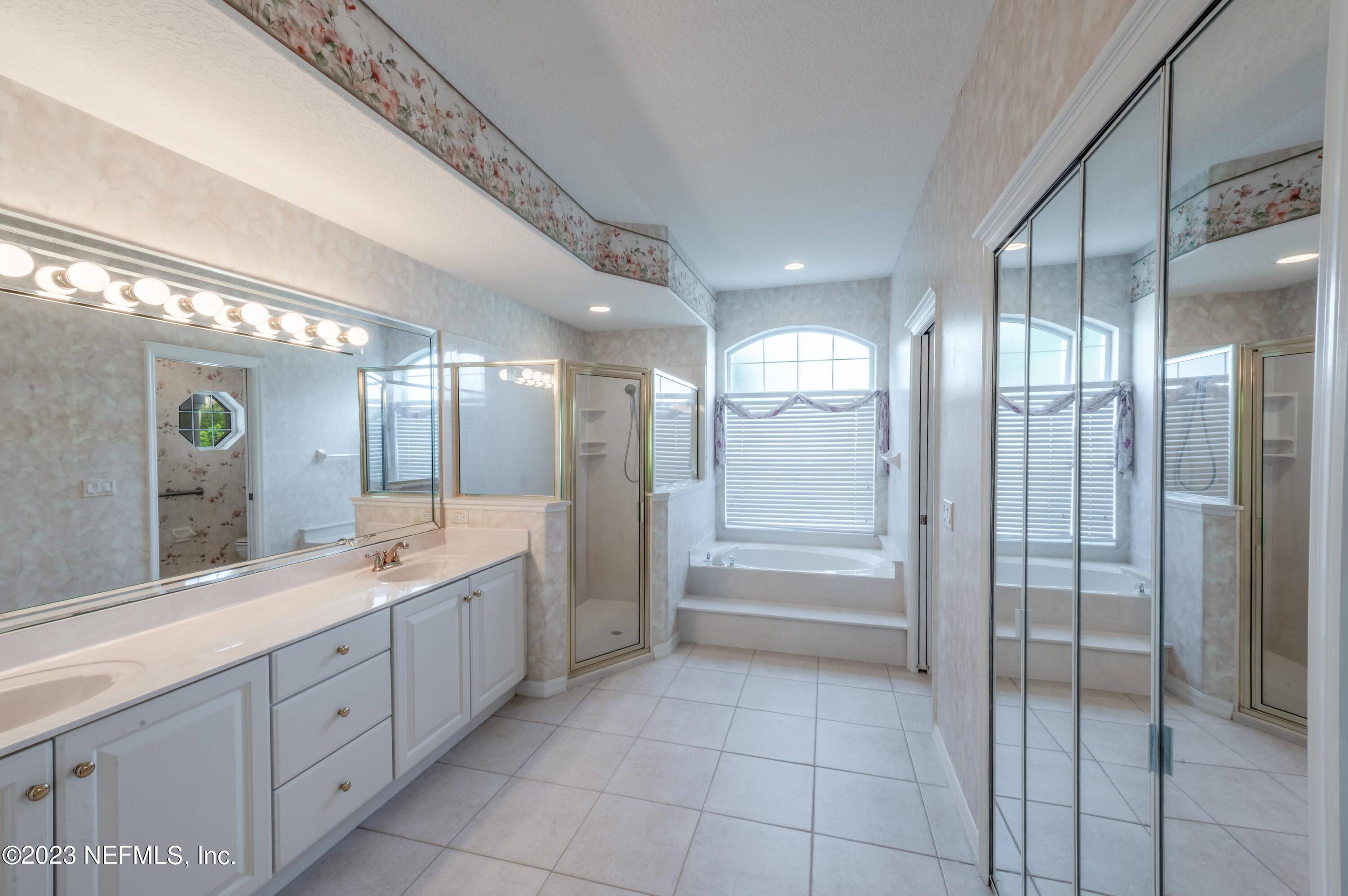 13 Clear Court Palm Coast, FL 32137 - Photo 33 of 60 a large bathroom with a large mirror vanity and shower