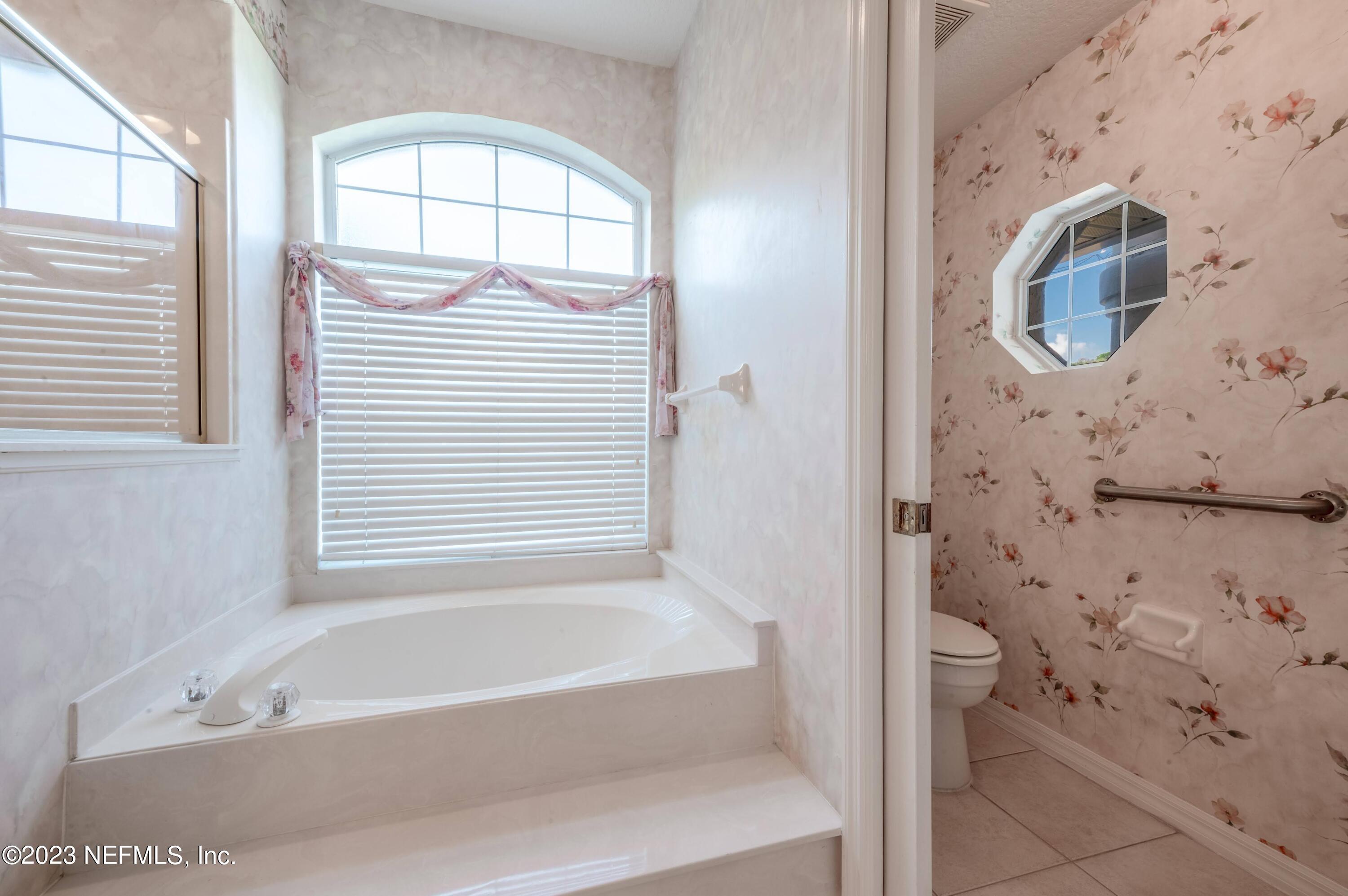 13 Clear Court Palm Coast, FL 32137 - Photo 35 of 60 a bathroom with bathtub and window