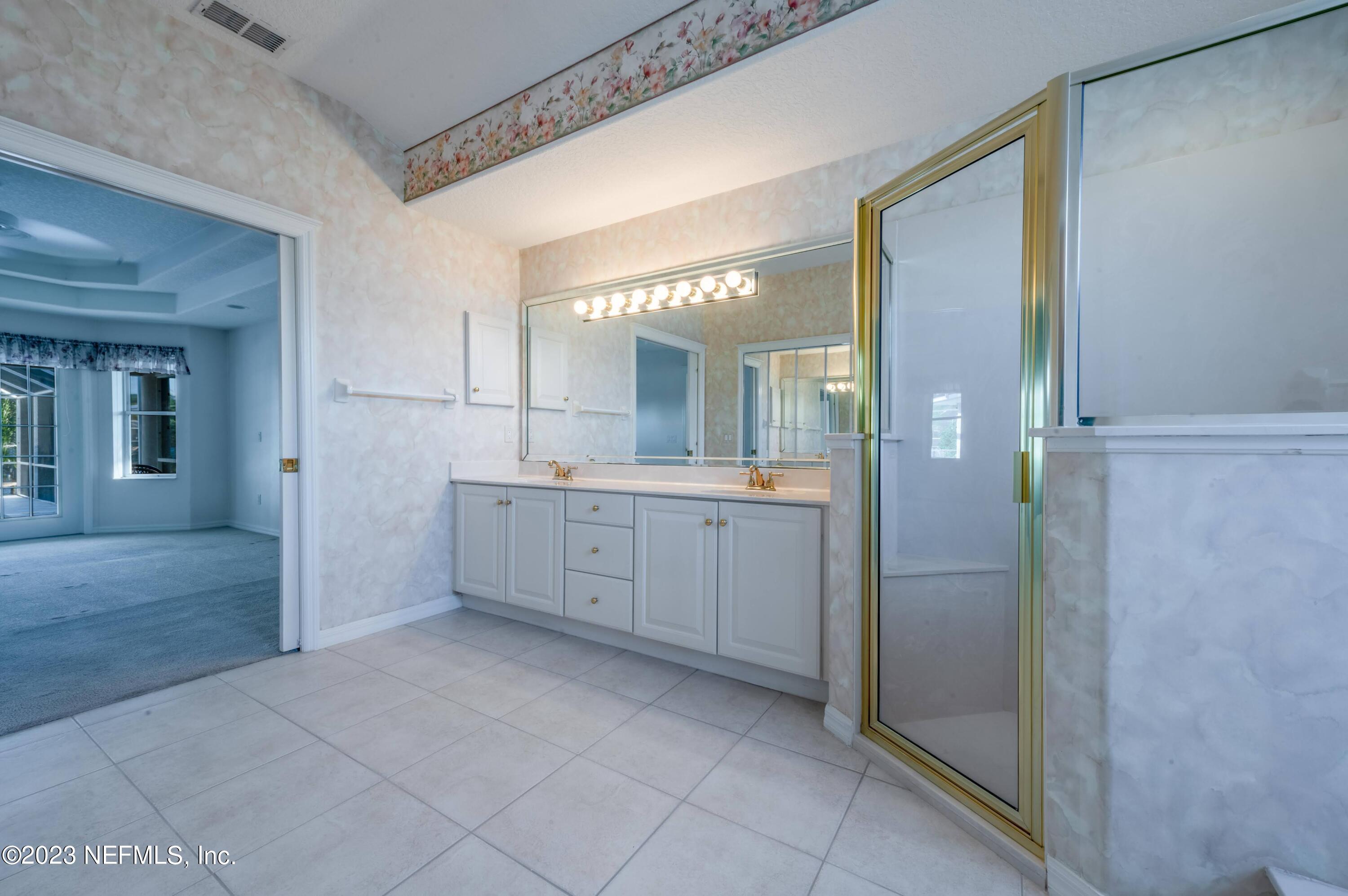 13 Clear Court Palm Coast, FL 32137 - Photo 36 of 60 a bathroom with a double vanity sink a mirror and a shower