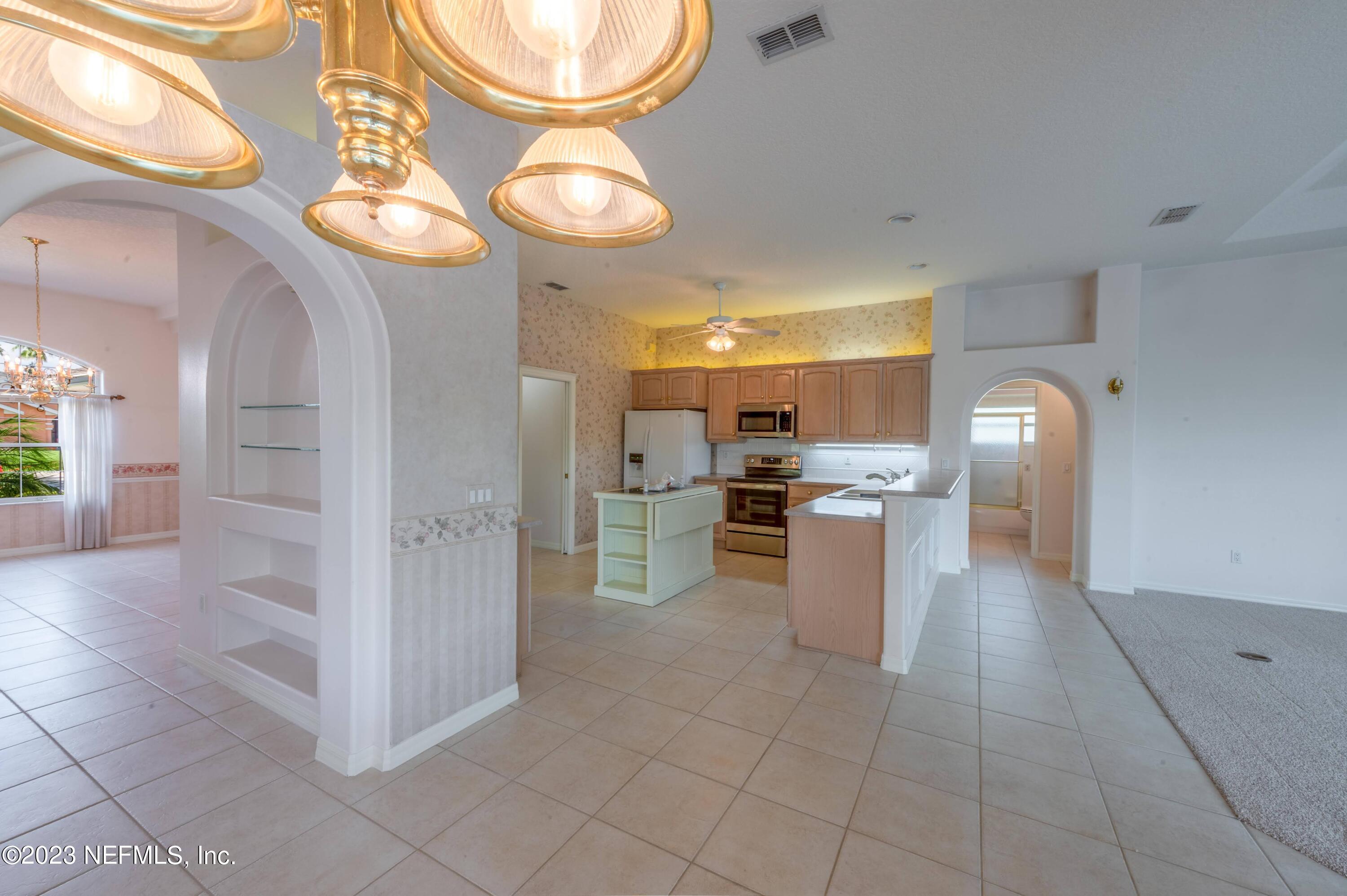 13 Clear Court Palm Coast, FL 32137 - Photo 40 of 60 a kitchen with stainless steel appliances kitchen island granite countertop a stove a sink and a refrigerator
