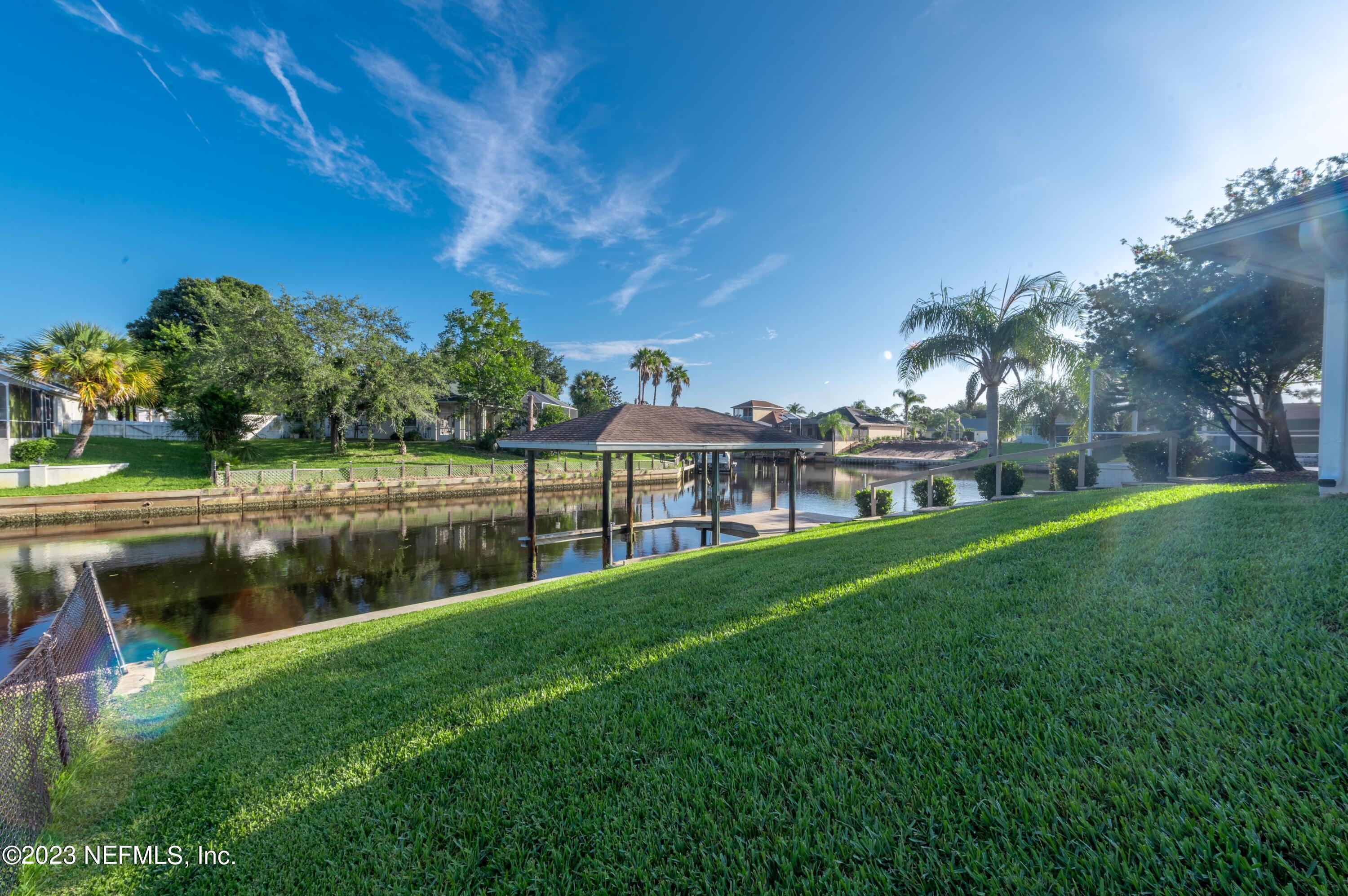 13 Clear Court Palm Coast, FL 32137 - Photo 4 of 60 a view of a lake with a yard and large trees