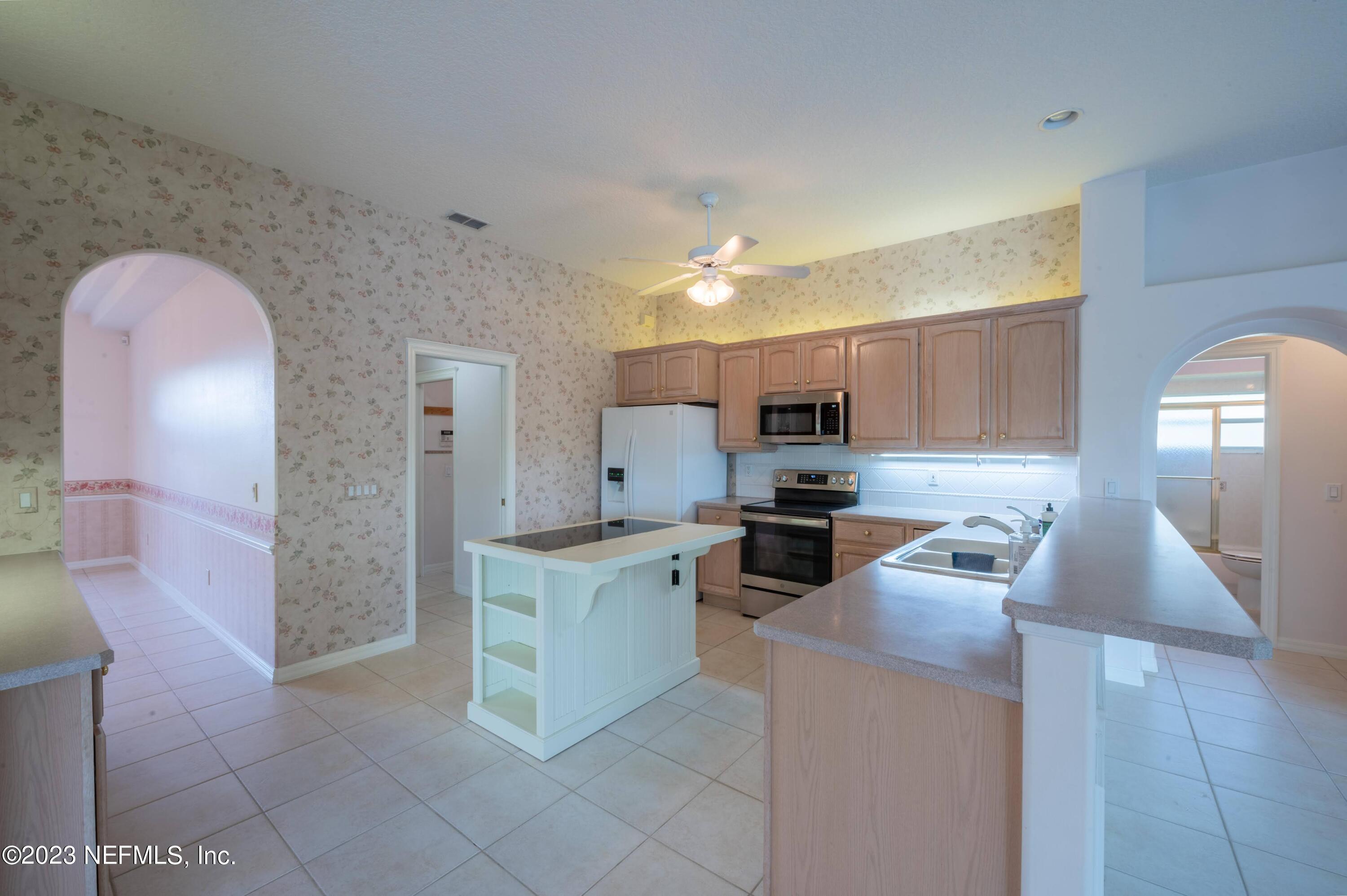 13 Clear Court Palm Coast, FL 32137 - Photo 41 of 60 a kitchen with stainless steel appliances granite countertop a sink and a refrigerator