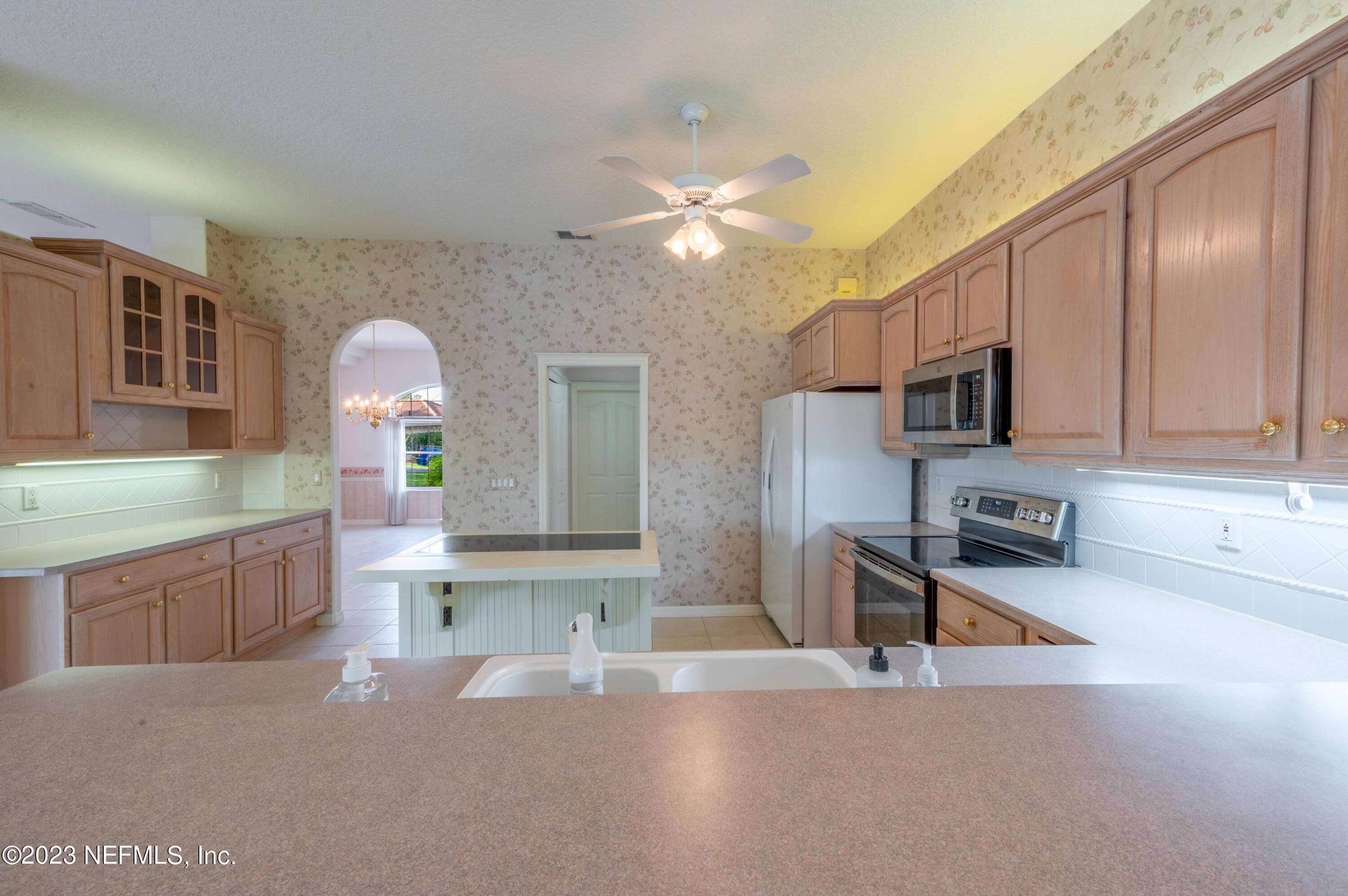 13 Clear Court Palm Coast, FL 32137 - Photo 47 of 60 a large kitchen with stainless steel appliances a large counter top a stove and a sink