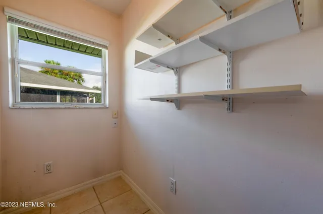 a view of an empty room with window and closet area