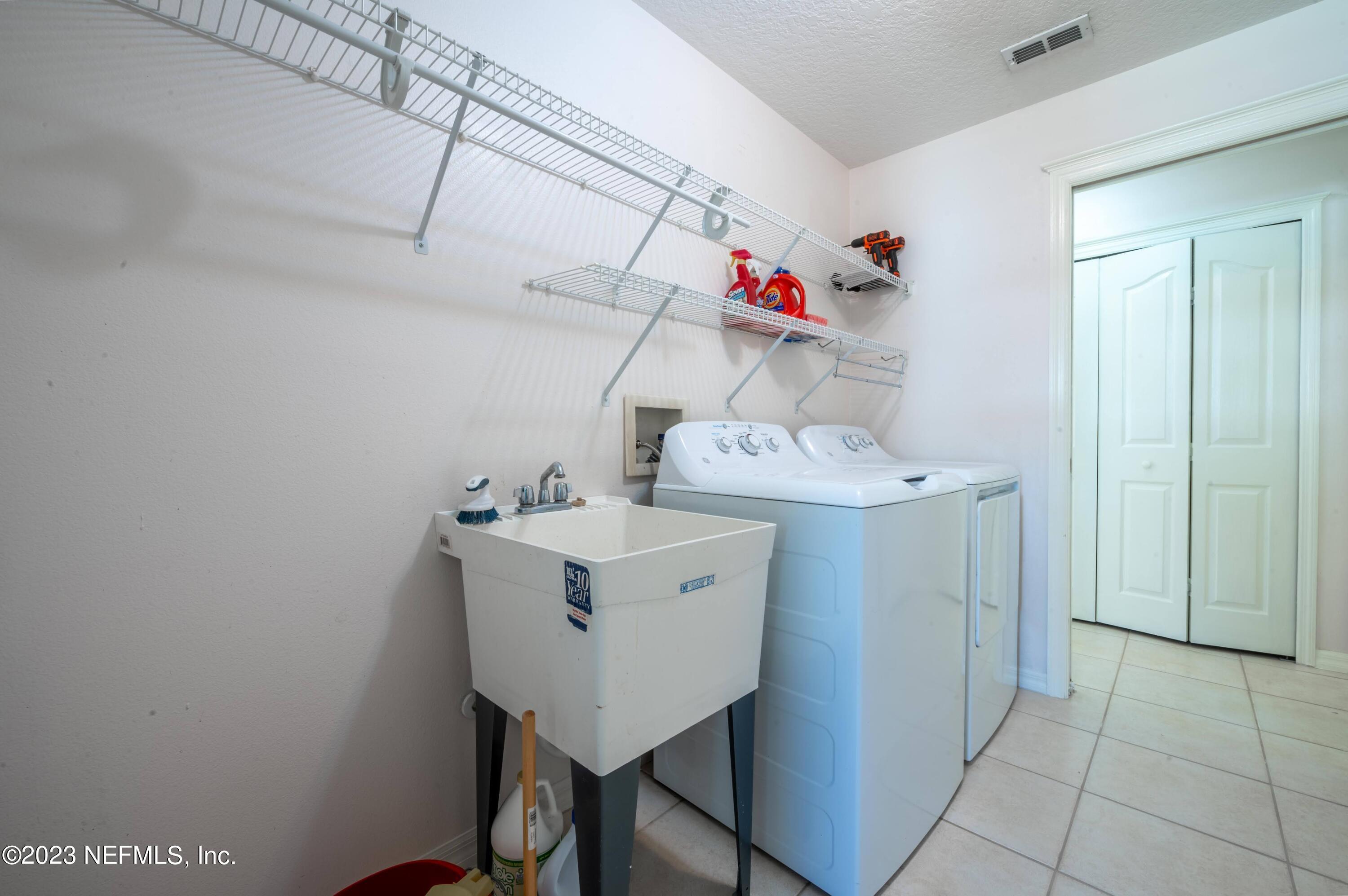 13 Clear Court Palm Coast, FL 32137 - Photo 50 of 60 a utility room with a sink washer and dryer