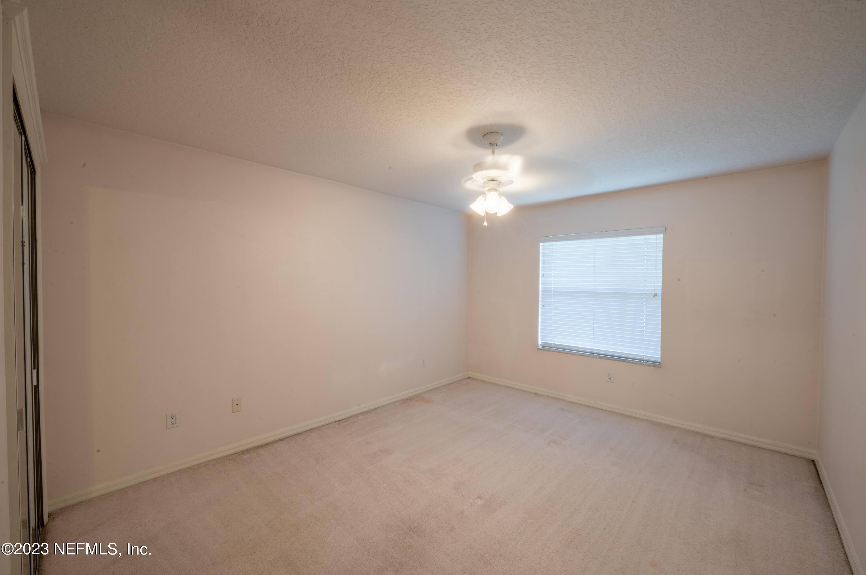 13 Clear Court Palm Coast, FL 32137 - Photo 55 of 60 an empty room with a chandelier fan and windows