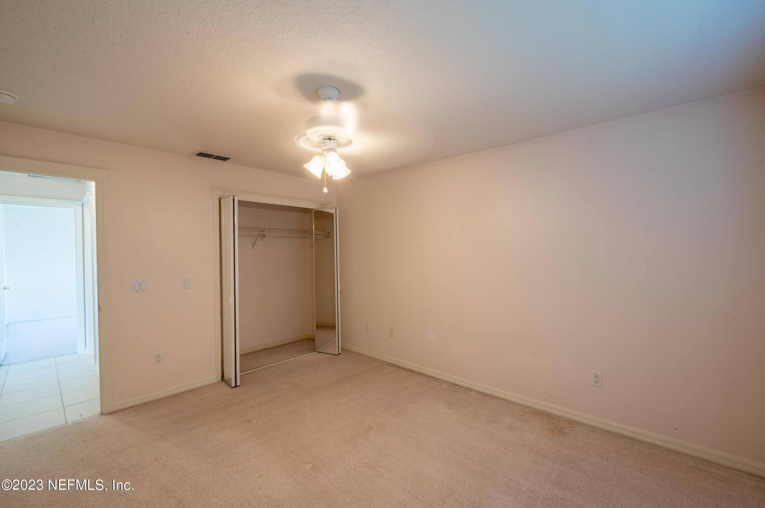 13 Clear Court Palm Coast, FL 32137 - Photo 56 of 60 an empty room with a chandelier fan and windows
