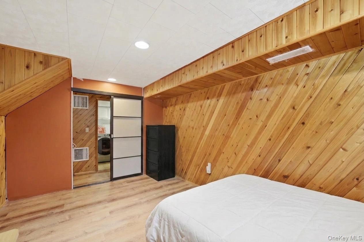 29 Montrose Road Yonkers, NY 10710 - Photo 23 of 39 Basement bedroom featuring diagonal wood paneling and wood-finish flooring
