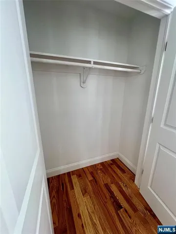 a view of a room with wooden floor and small window