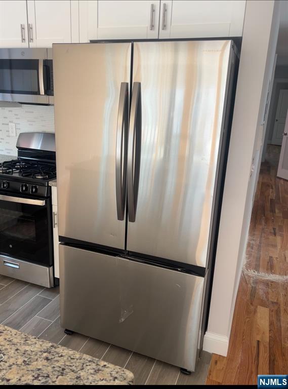879 South 18th Street Newark, NJ 07108 - Photo 3 of 15 a view of a kitchen with wooden floor and a refrigerator