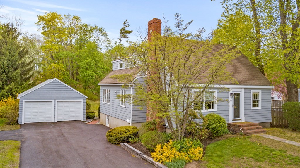 a front view of a house with a yard and trees