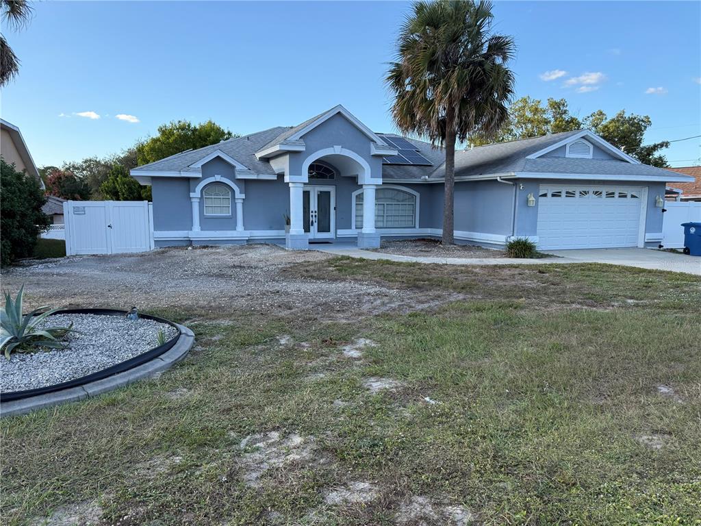 6125 Mariner Boulevard Spring Hill, FL 34608 - Photo 1 of 24 a front view of a house with a yard and garage