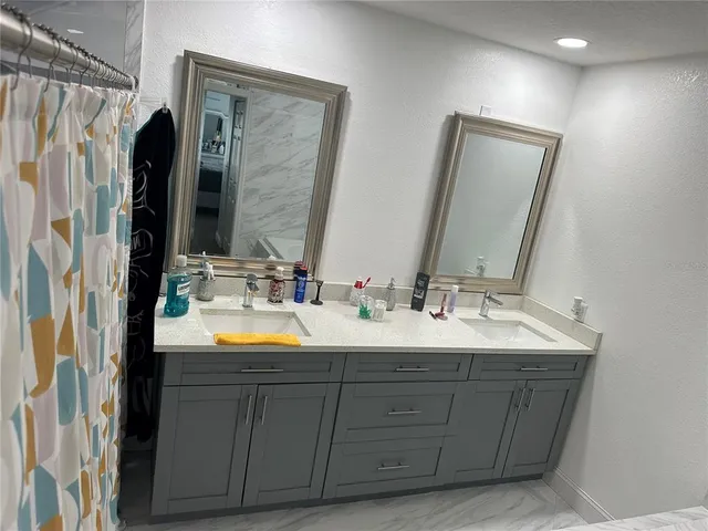 a bathroom with double vanity and a mirror