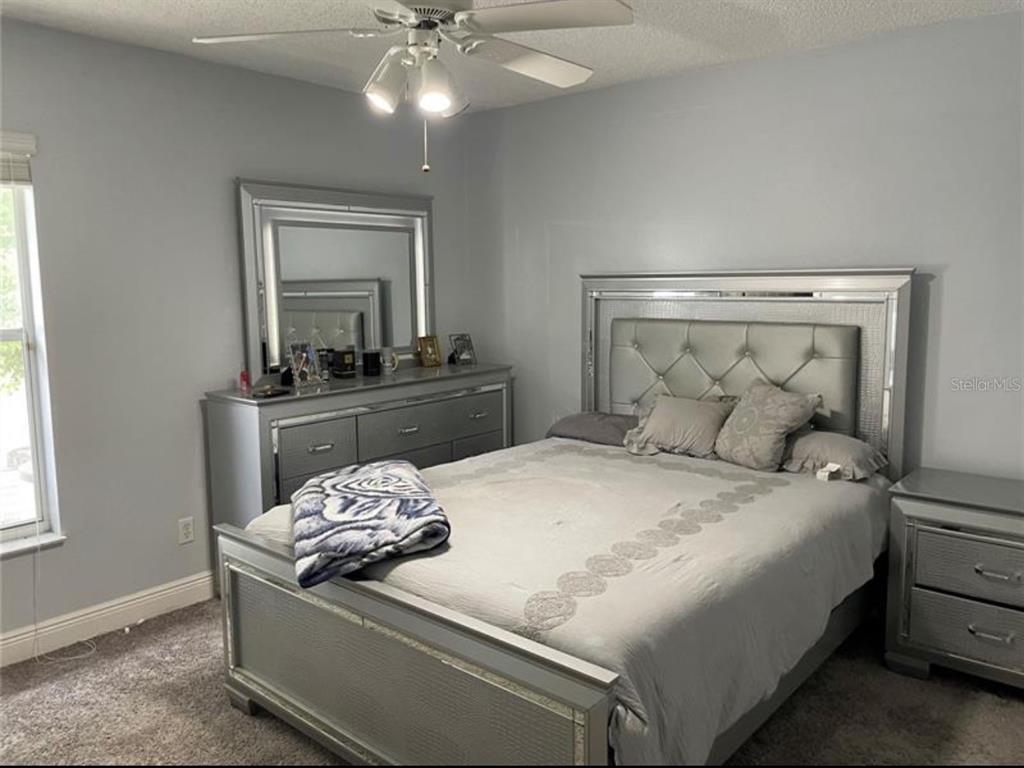 6125 Mariner Boulevard Spring Hill, FL 34608 - Photo 17 of 24 a bedroom with a bed and a chandelier