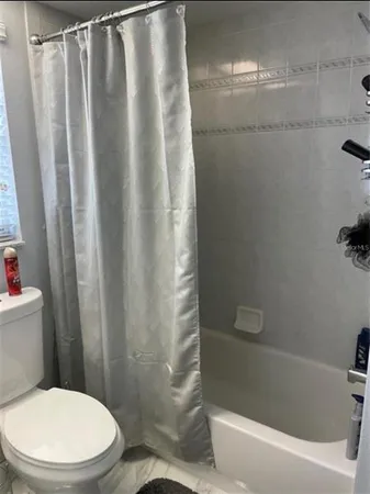 a white toilet sitting next to a bathtub