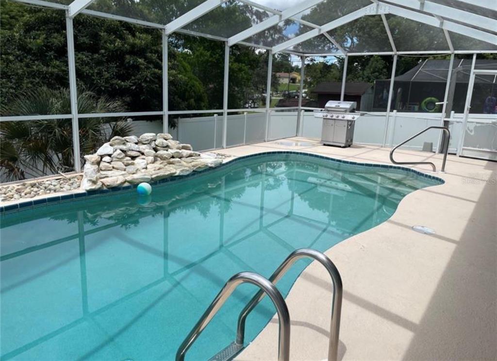 6125 Mariner Boulevard Spring Hill, FL 34608 - Photo 23 of 24 a swimming pool with barbeque oven table and chairs