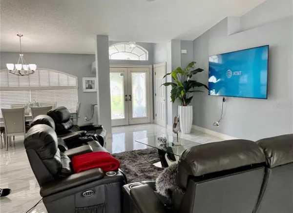 a living room with furniture and a chandelier