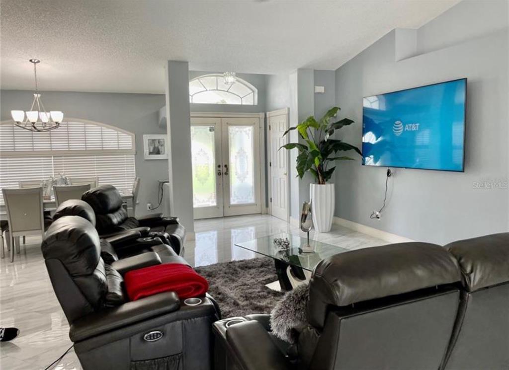 6125 Mariner Boulevard Spring Hill, FL 34608 - Photo 5 of 24 a living room with furniture and a chandelier