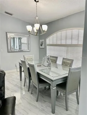 a view of a dining room with furniture a chandelier and wooden floor